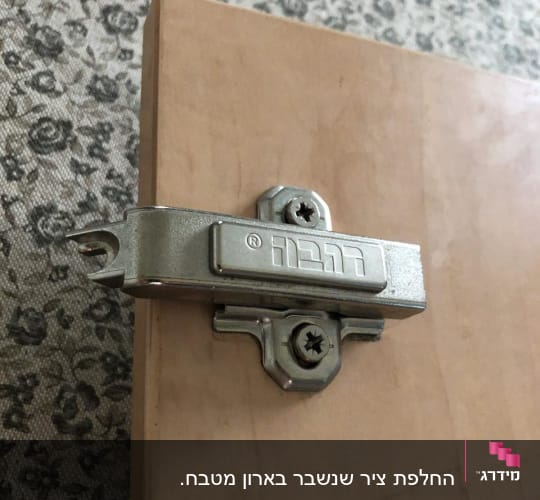ציר מתכת מותקן על דלת עץ